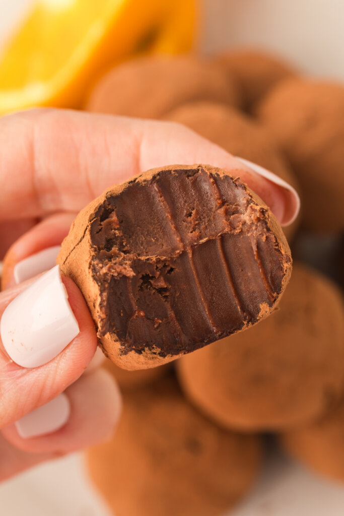 hand holding a chocolate orange truffle