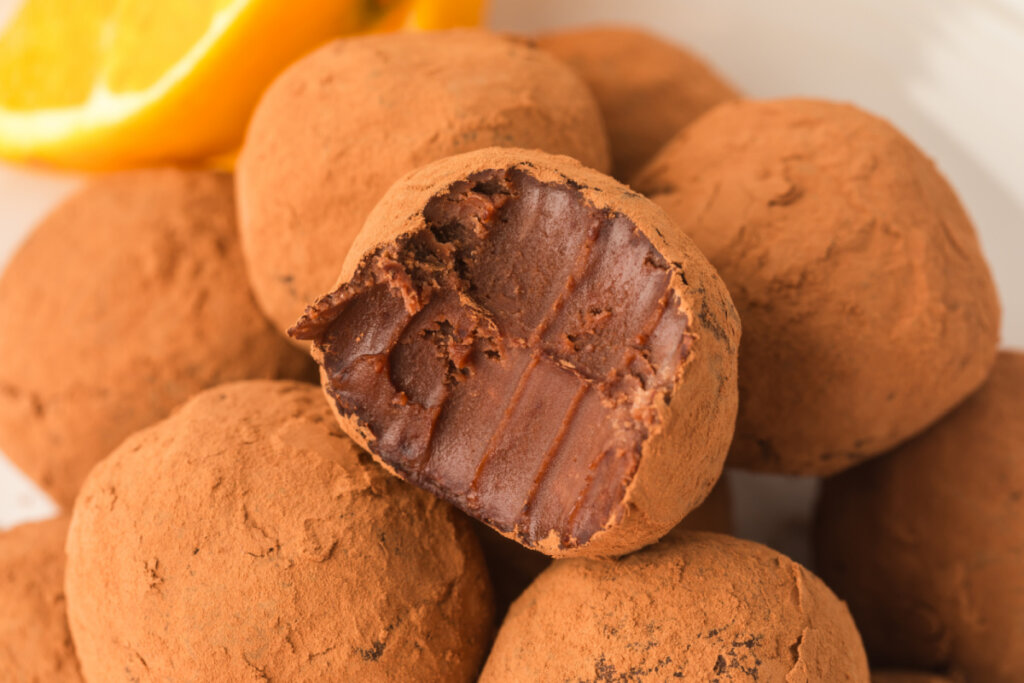 closeup of chocolate orange truffles with one showing the inside
