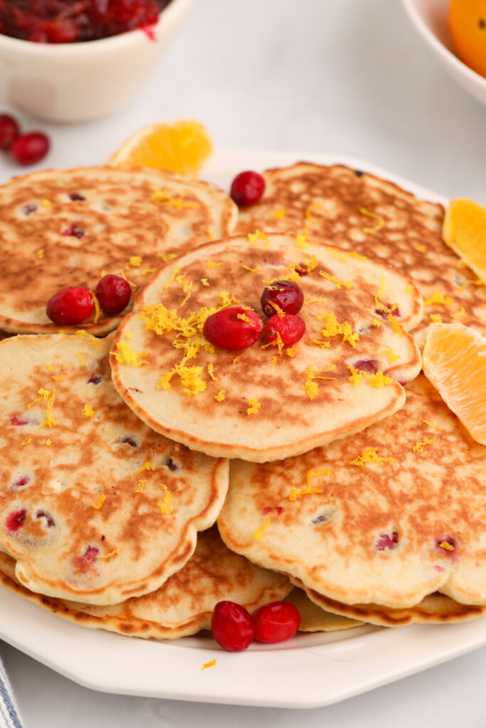 several orange cranberry pancakes on plate