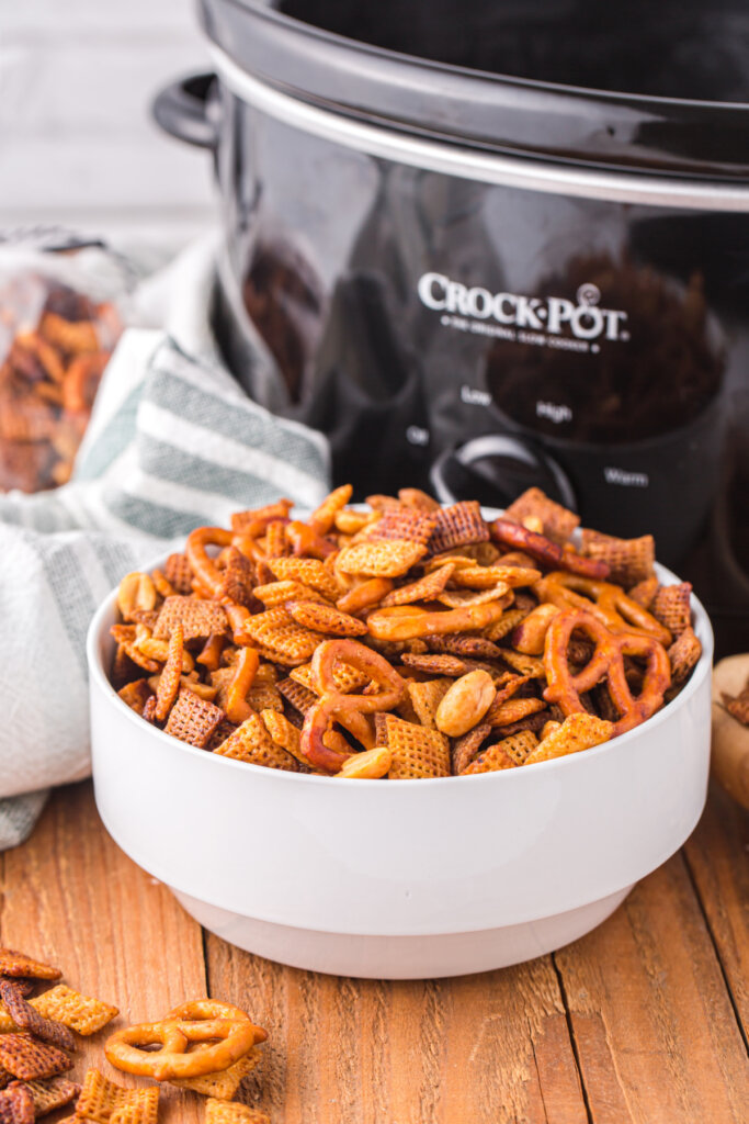 chex mix in a bowl in front of a slow cooker