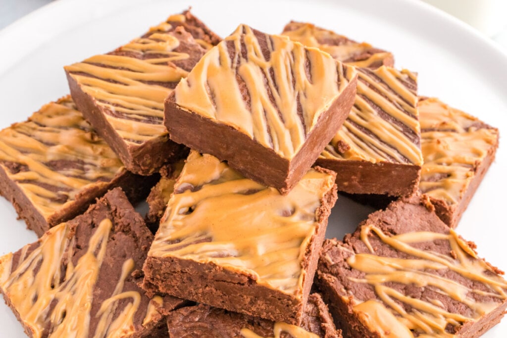 closeup of chocolate peanut butter fudge stacked on plate
