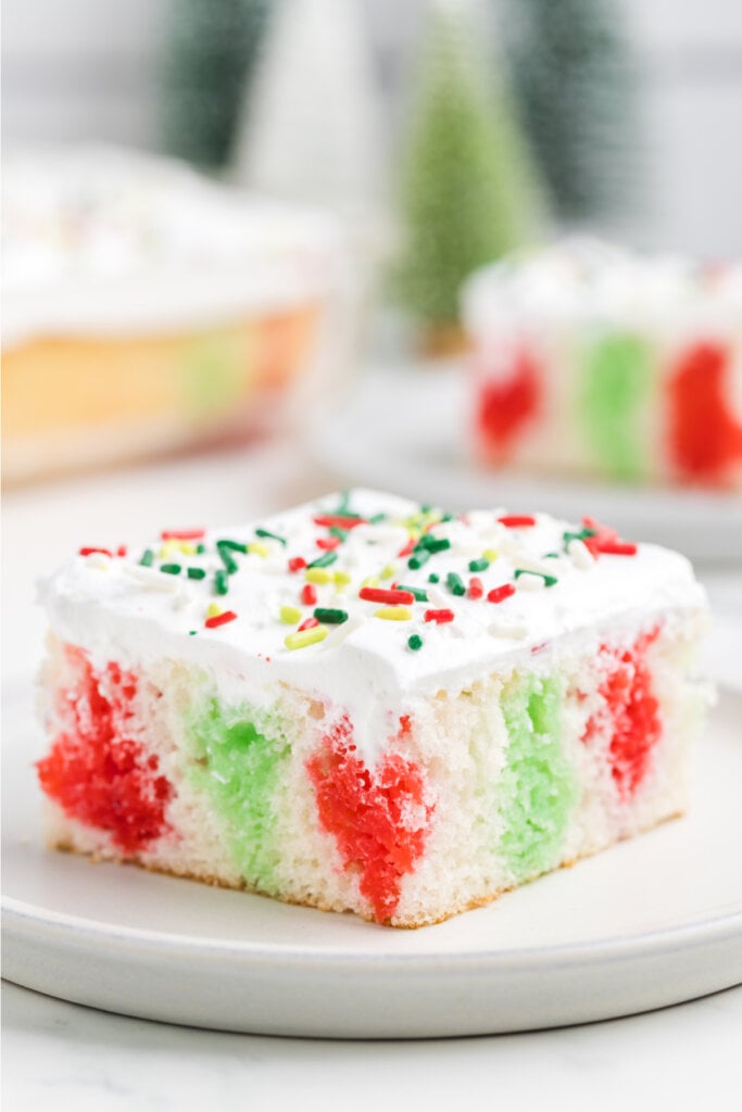 slice of christmas poke cake on white plate