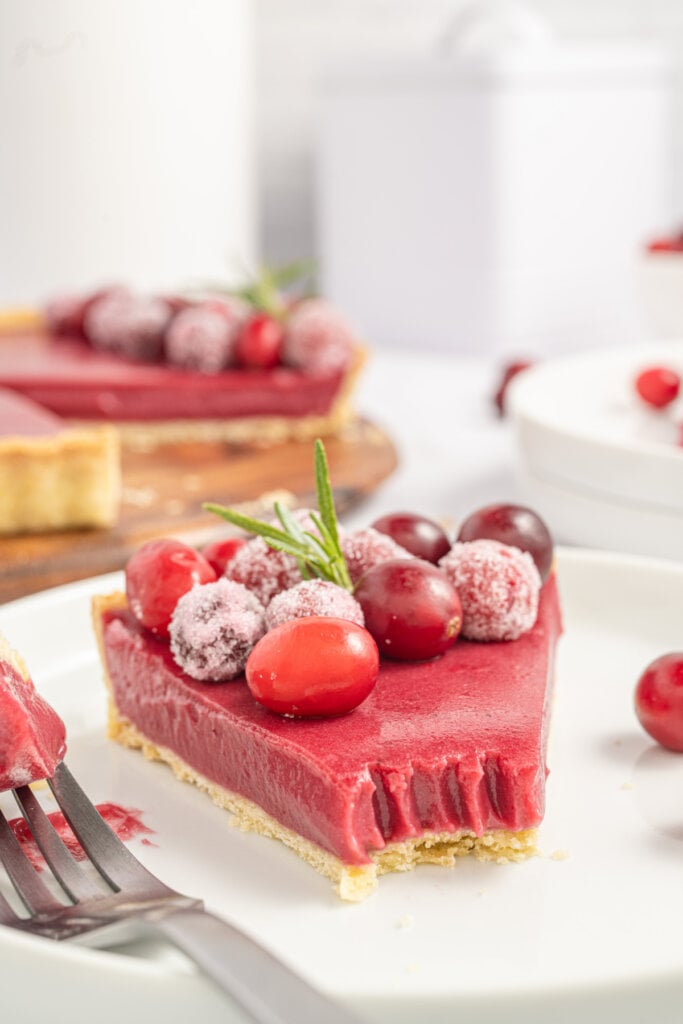 slice of cranberry curd tart with bite missing