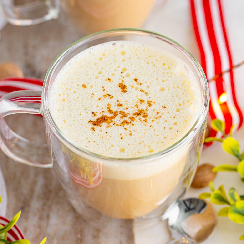 closeup of eggnog latte in clear coffee mug