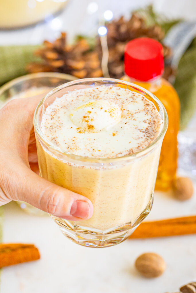 hand holding a glass of eggnog punch