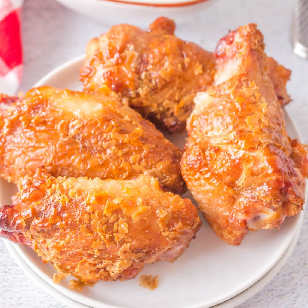 four grilled crispy chicken wings on plate