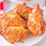four grilled crispy chicken wings on plate