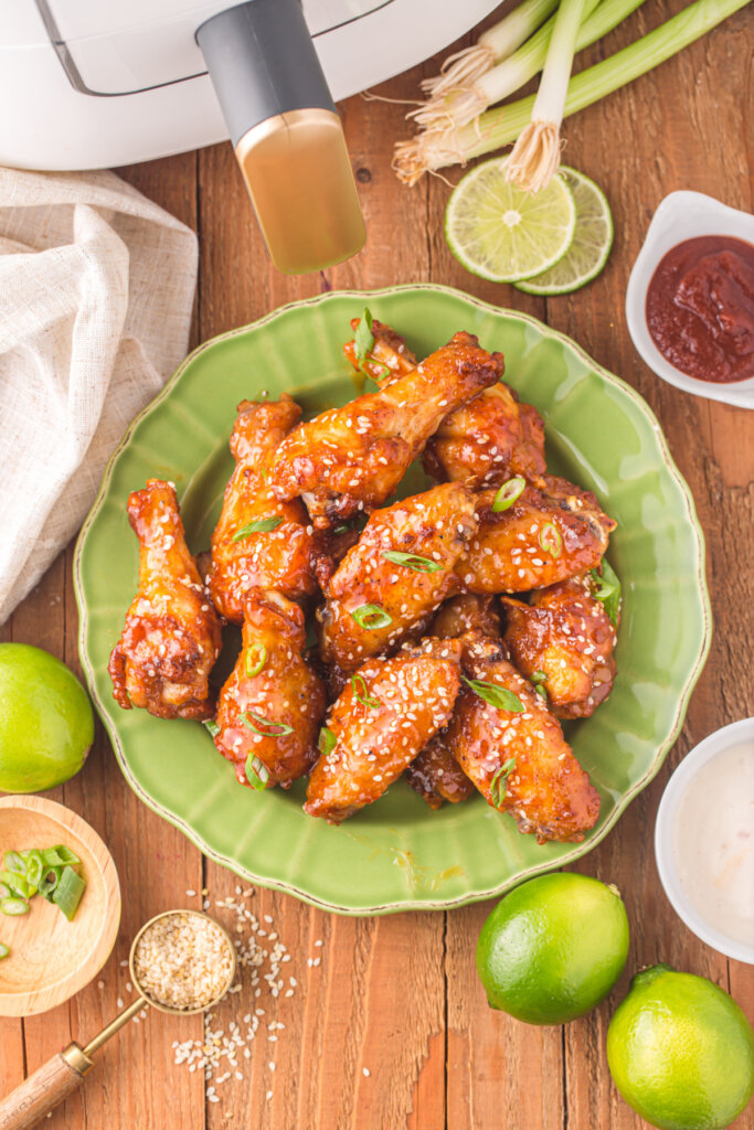 looking down onto honey sriracha wings on green plate