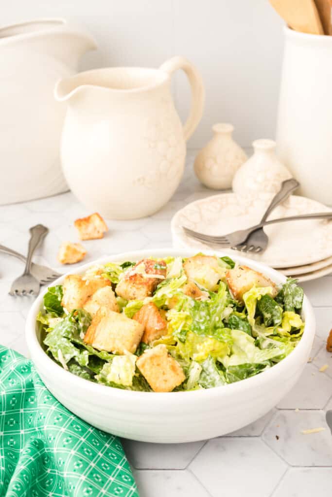 prepared caesar salad in bowl on table