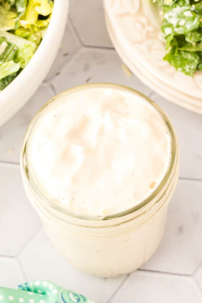closeup looking down into a jar filled with caesar salad dressing