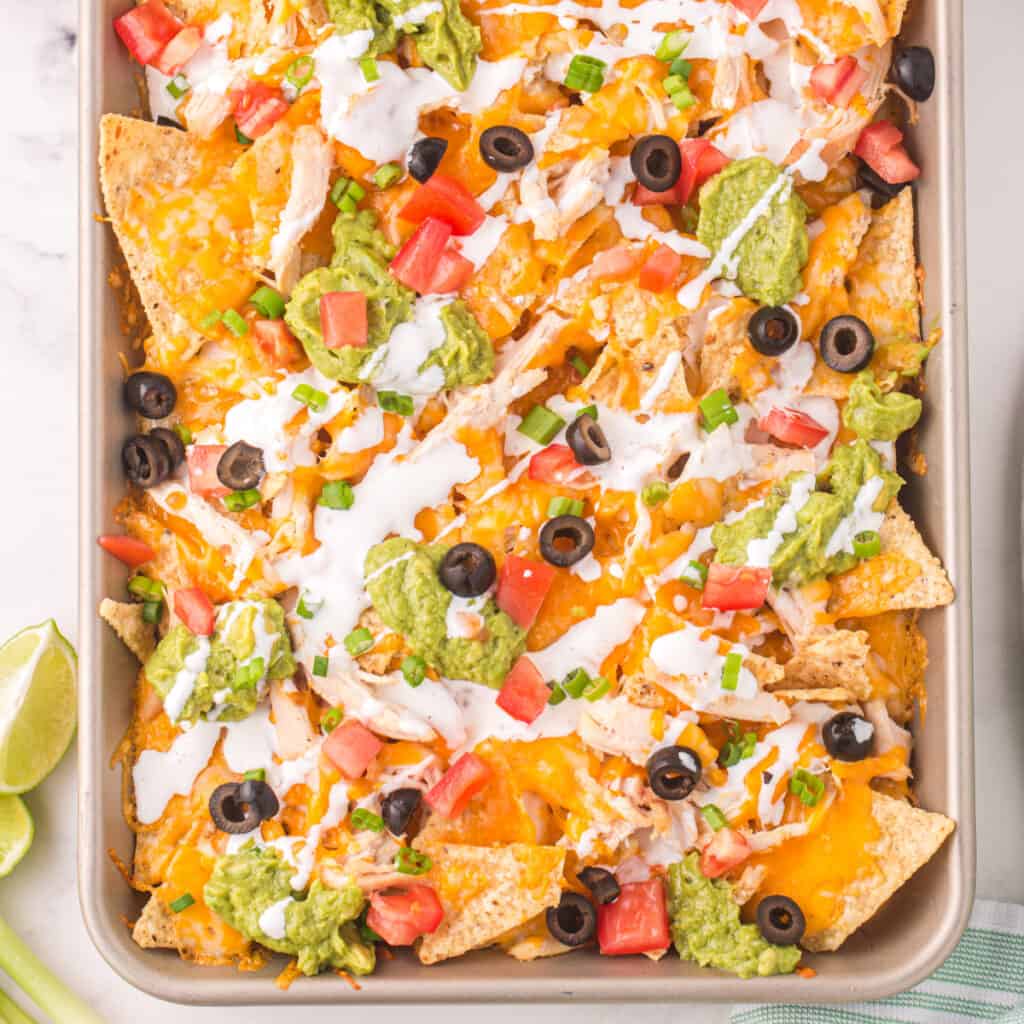 closeup of chicken nachos on sheet pan