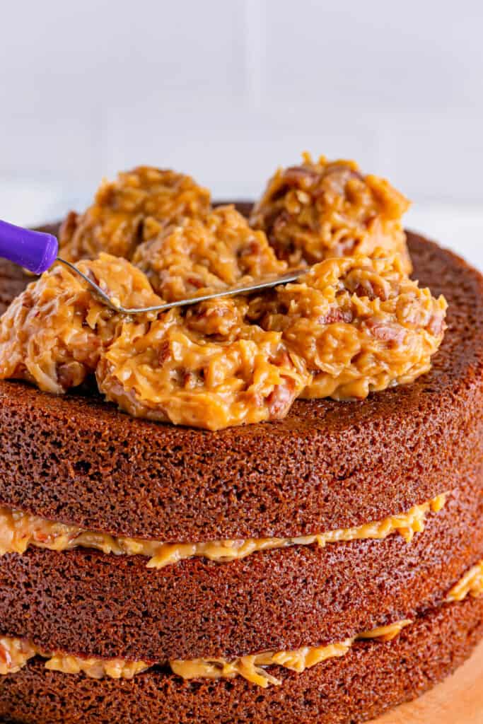 frosting being spread over the top of a cake