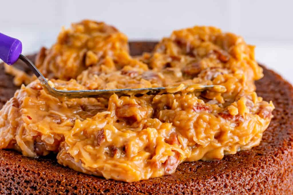 coconut pecan frosting being speread on top of a cake