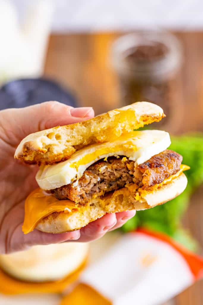 hand holding a breakfast sandwich with a bite taken out of it
