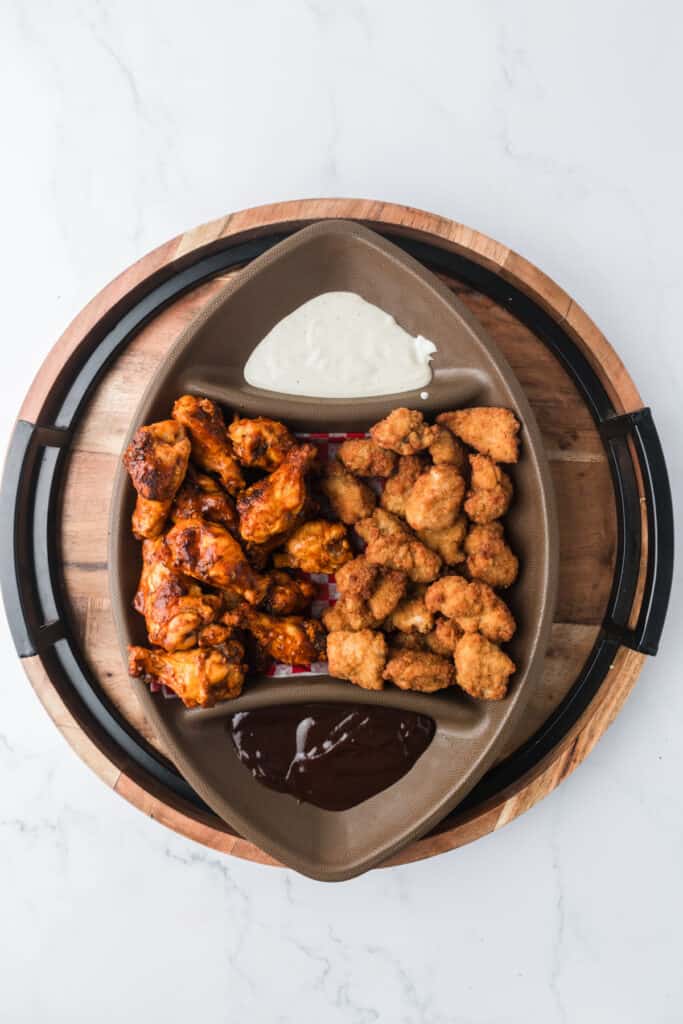 football platter filled with chicken and dipping sauces