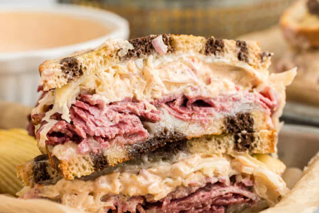 reuben sandwich sliced in half on plate