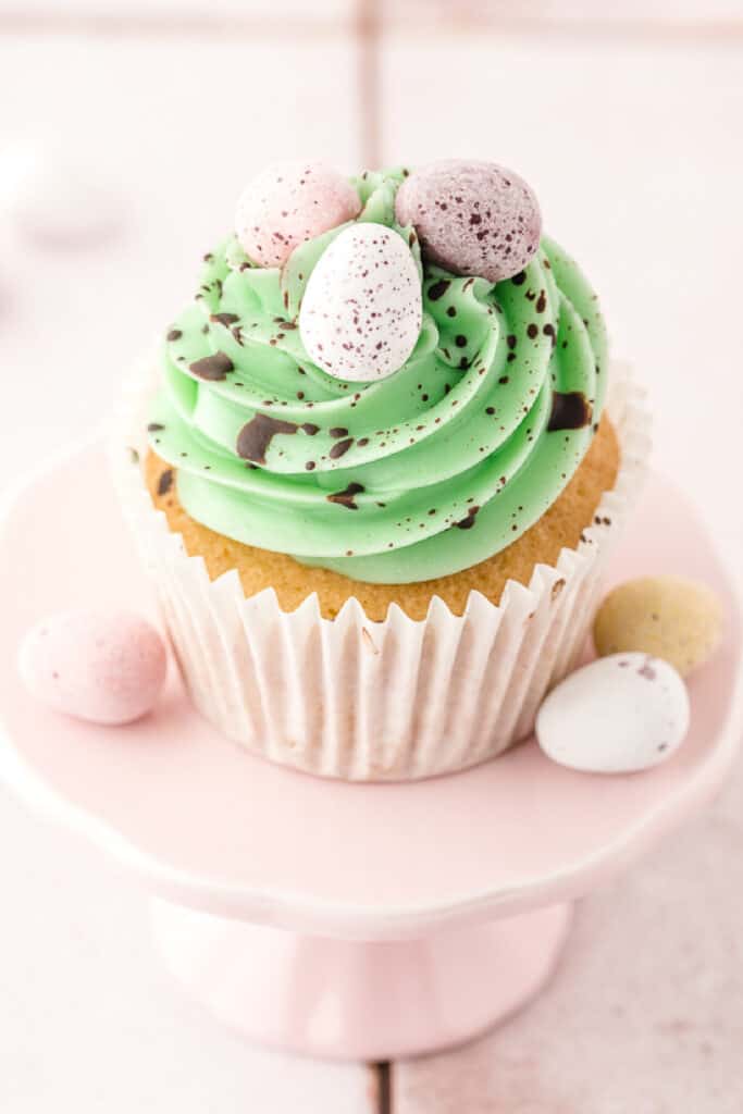 green swiss buttercream piped on top of a vanilla cupcake