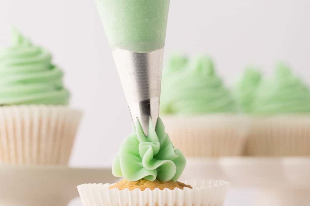 swiss meringue buttercream being piped from a bag
