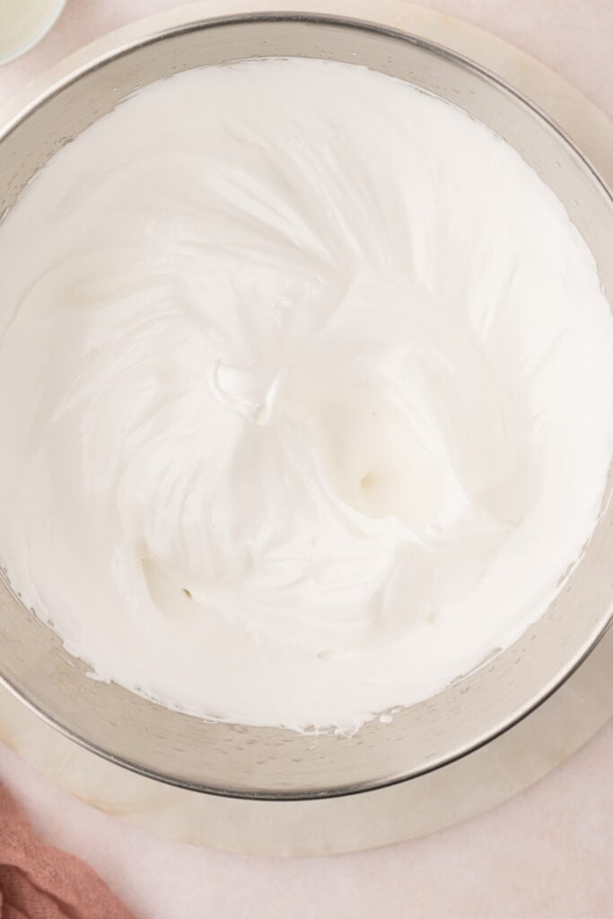 Add the bowl to the stand mixer fitted with the whisk attachment. Whisk on a medium-high speed until the egg whites reach stiff peaks. This will take at least 10 minutes but sometimes longer.