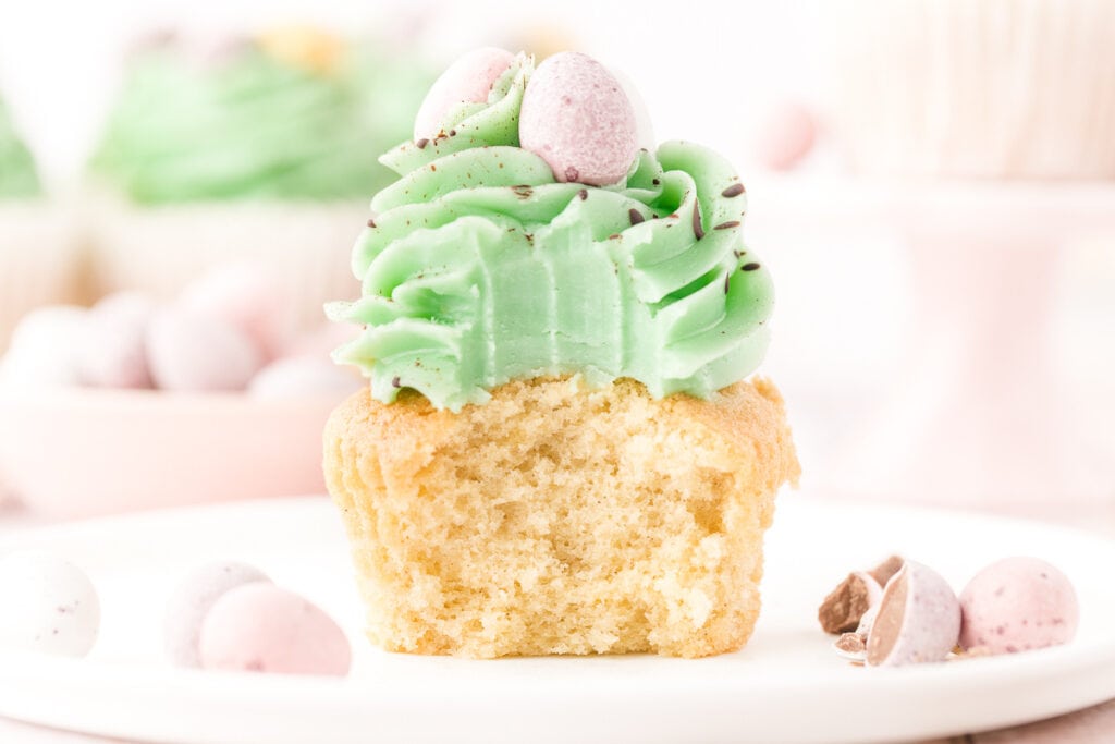 vanilla easter cupcake with bite taken out to show the crumb and texture