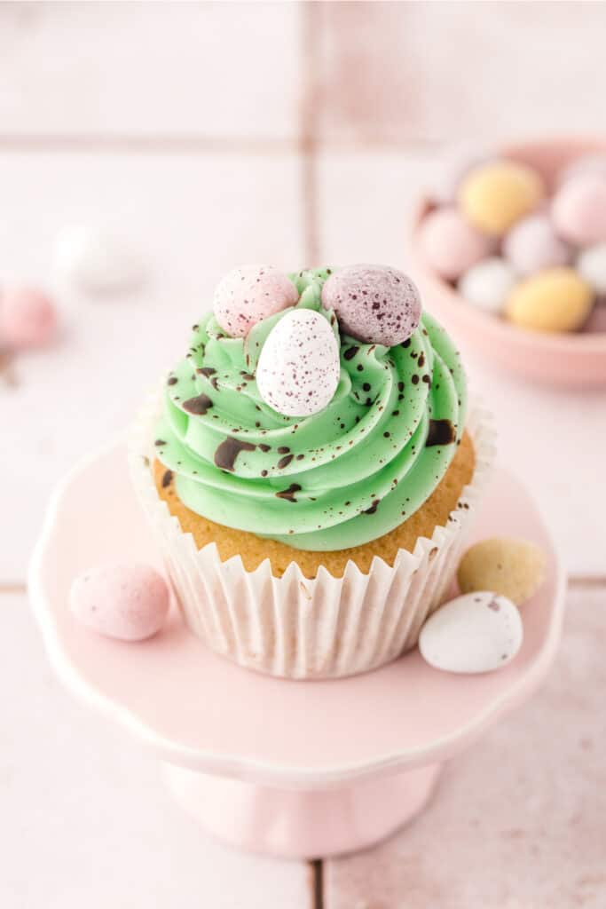 looking down on a cake stand with a vanilla easter cupcake on it