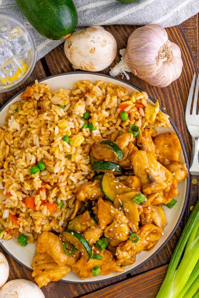 looking down onto a plate with fried rice and copycat panda express mushroom chicken