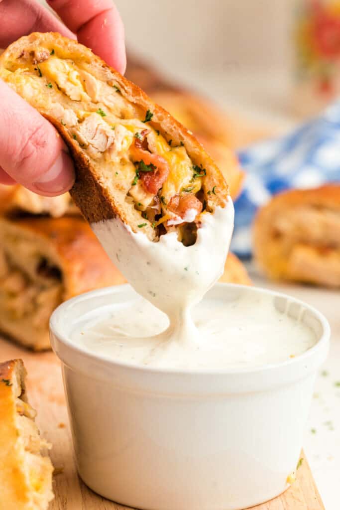 slice of crack chicken bread being dipped into ranch dressing