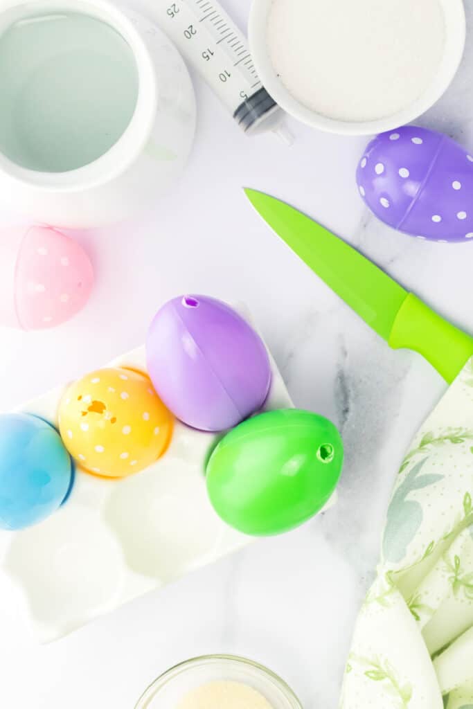 	Using a sharp knife, carefully make a small hole (or make an existing one a little larger) at the top of the plastic Easter egg.