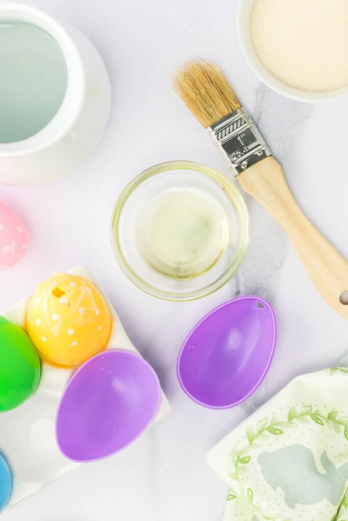 Brush the inside of the plastic egg with vegetable oil.  