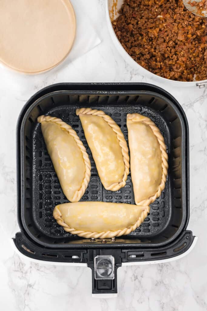Place the empanadas in the air fryer basket in a single layer, making sure they are not touching.