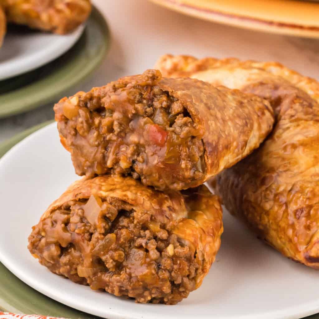 closeup of a beef empanada split in half to show the saucy inside