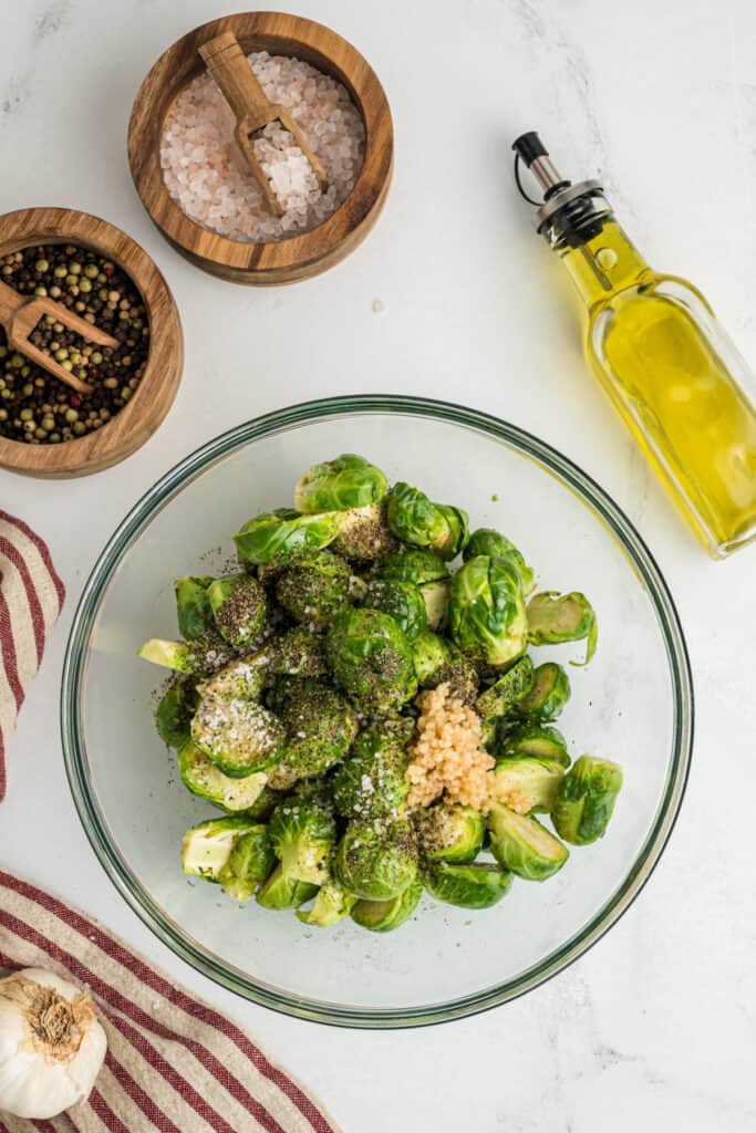 In a large bowl, add the Brussel sprouts and olive oil. Sprinkle in the salt, pepper and garlic. Toss to coat.