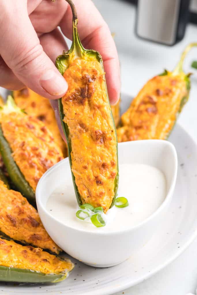 buffalo chicken jalapeno popper being dipped into sauce