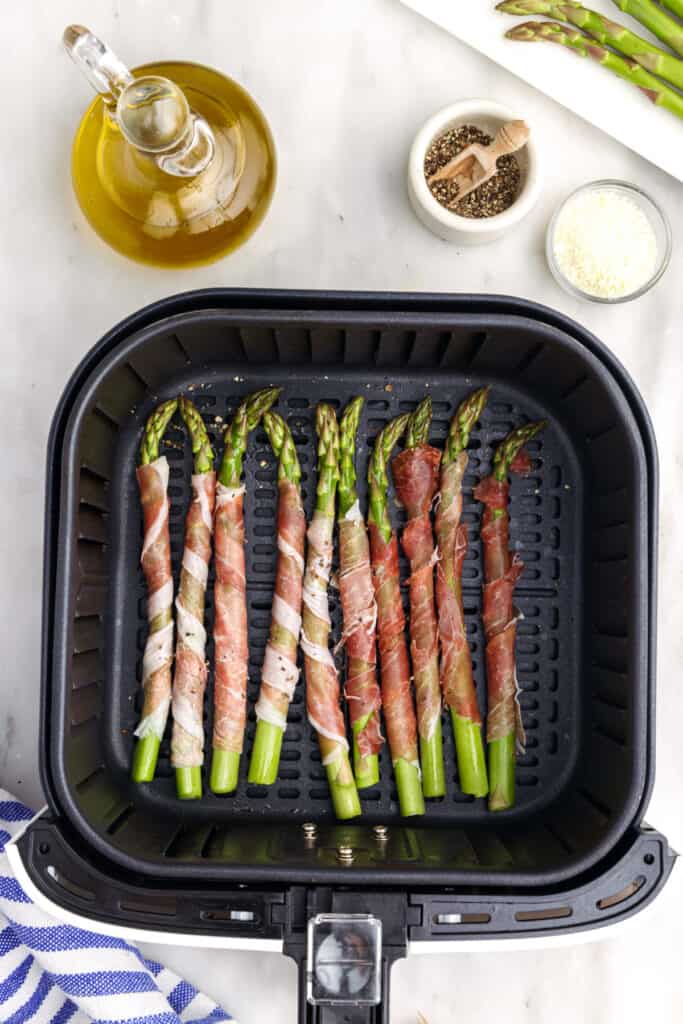Place prosciutto wrapped asparagus in the air fryer basket. 