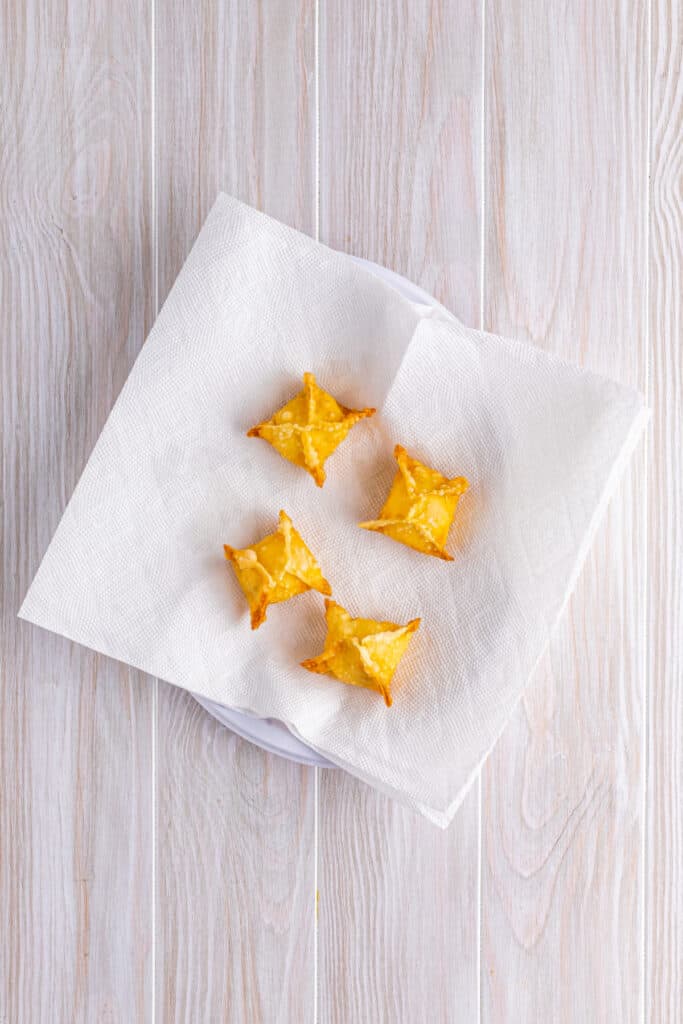 Heat a deep fryer or dutch oven with 4 inches of oil to 350°F. Very carefully place a couple of the crab rangoon into the hot oil at a time and fry until golden brown. Place the fried rangoons on a paper-towel-lined plate to soak up any excess oil ...