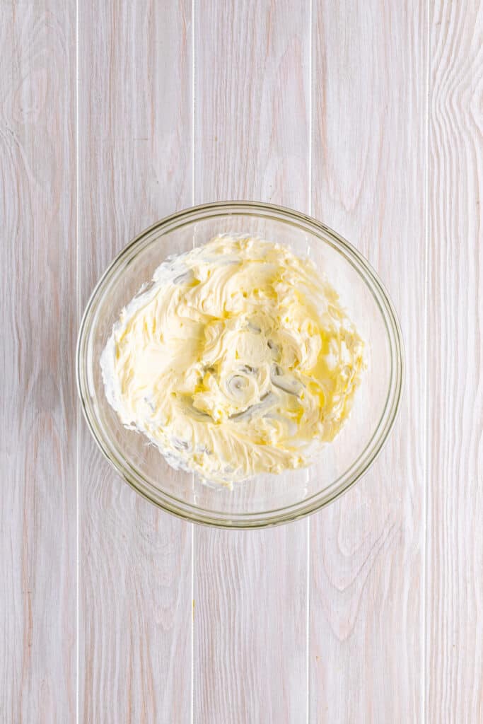 In a large bowl, whip the cream cheese until smooth with an electric hand mixer.