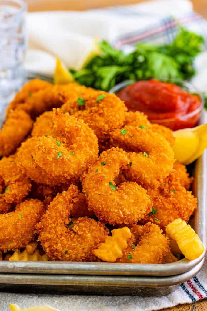 panko fried shrimp piled onto a metal baking sheet