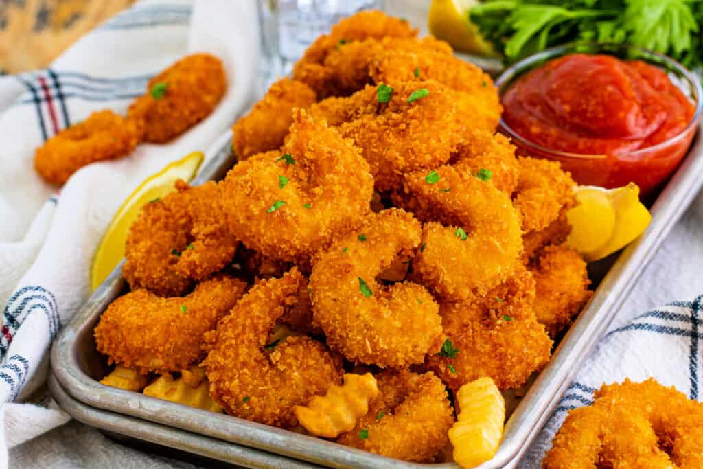 panko fried shrimp piled onto a small baking sheet