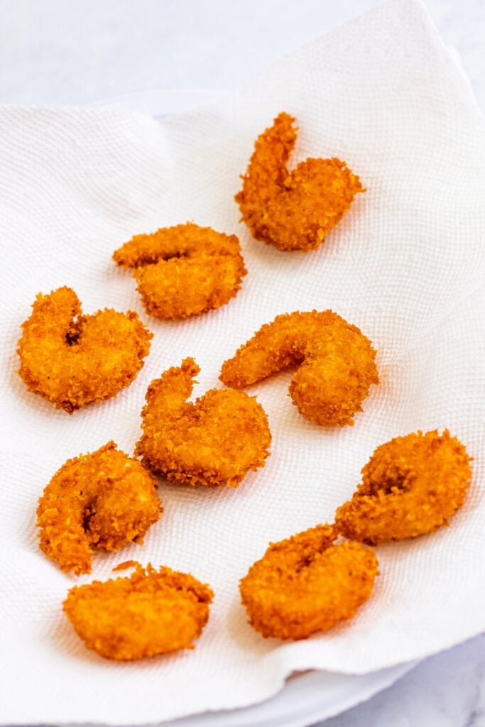 Drain fried shrimp on paper towels ...