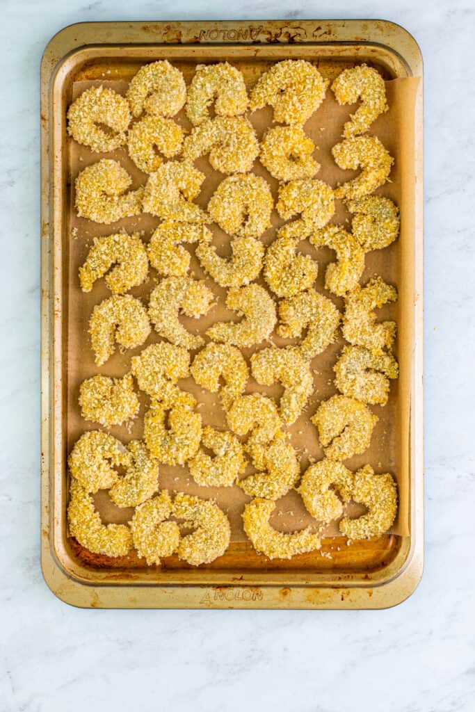 Place breaded shrimp on a parchment-lined tray.