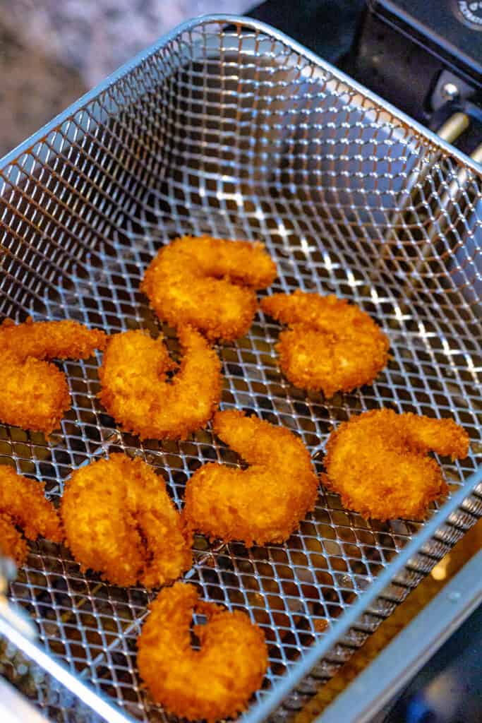 Fry shrimp in batches for 2-3 minutes until golden brown and internal temperature reaches 165°F.