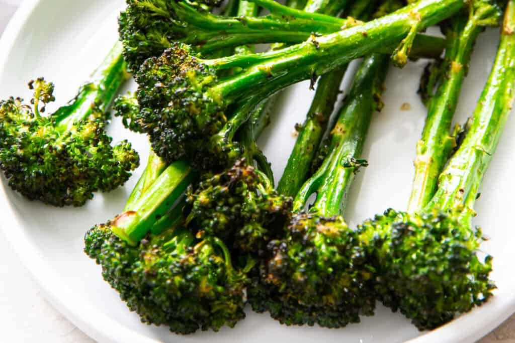 closeup of air fryer broccolini on white pate
