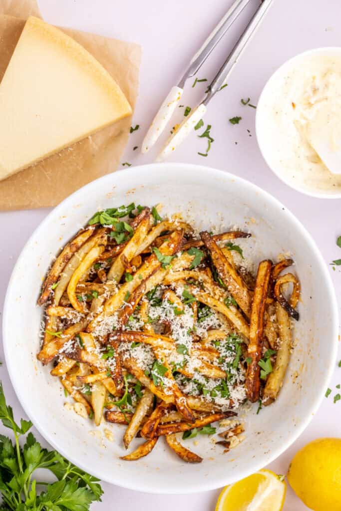 Remove the fries from the air fryer. Sprinkle the parmesan and parsley over the fries and gently toss. Serve immediately. 