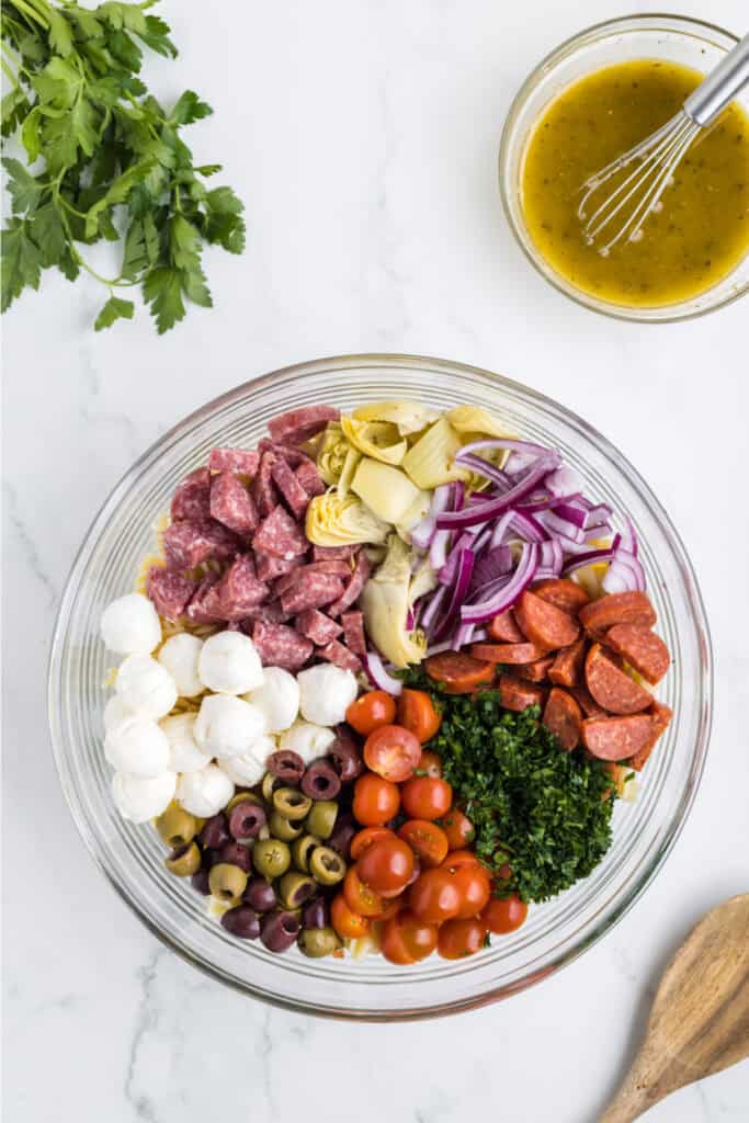 Place the cooled pasta and remaining salad ingredients in a large bowl ...