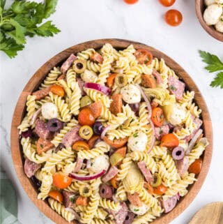 looking down on a wooden bowl filled with antipasto pasta salad