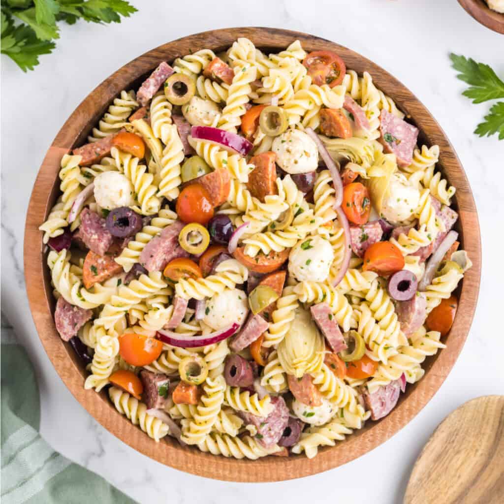 closeup of antipasto pasta salad in wooden bowl