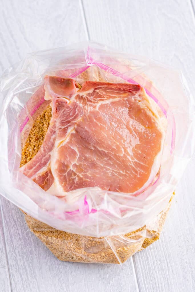 Place one pork chop at a time into the bag with the breadcrumb mixture. Close the bag and shake to coat the pork chop evenly. Press the breadcrumbs onto the pork chop for a thicker coating.