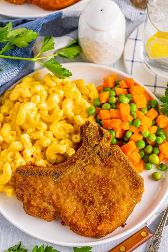 plate with pork chop, mac and cheese, and veggies