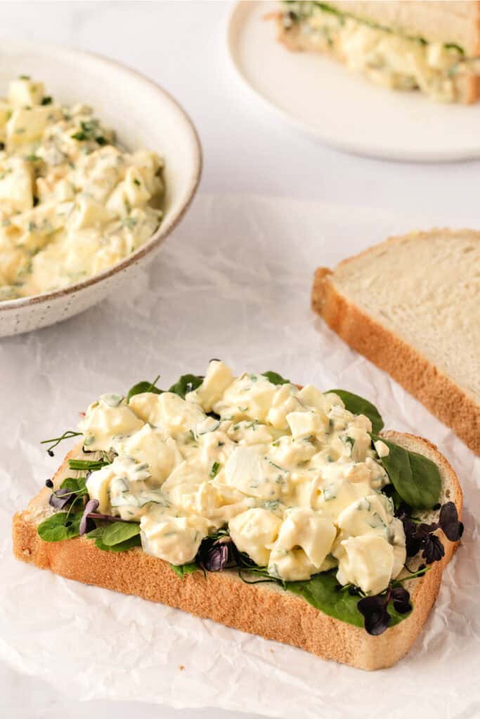 herbed egg salad mixture on bread with lettuce