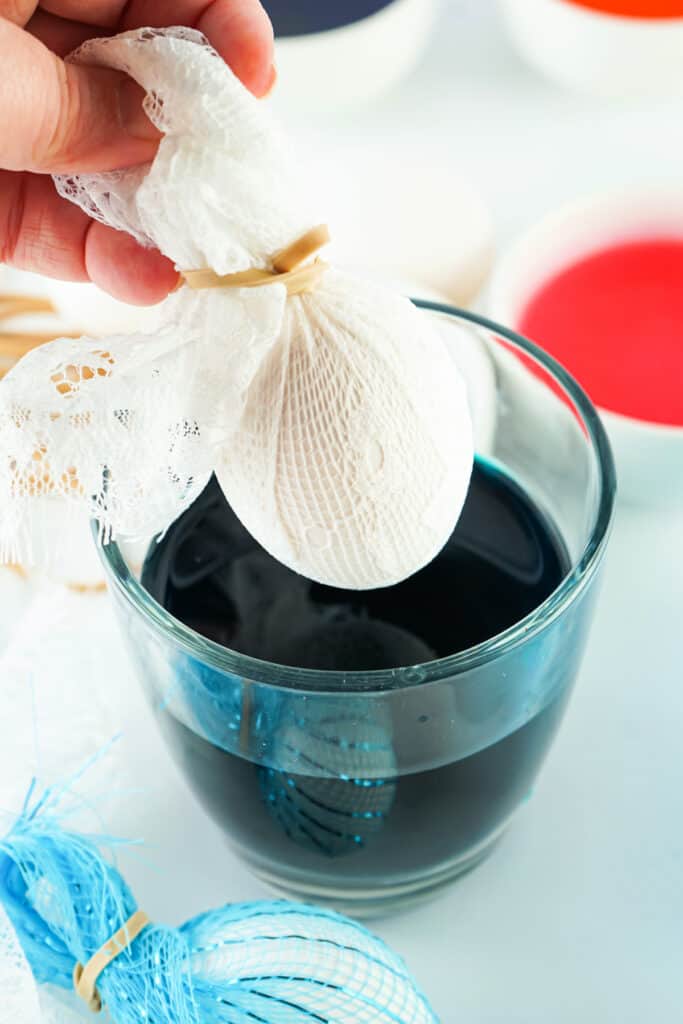 hard boiled egg wrapped in lace getting ready to be dipped in dye